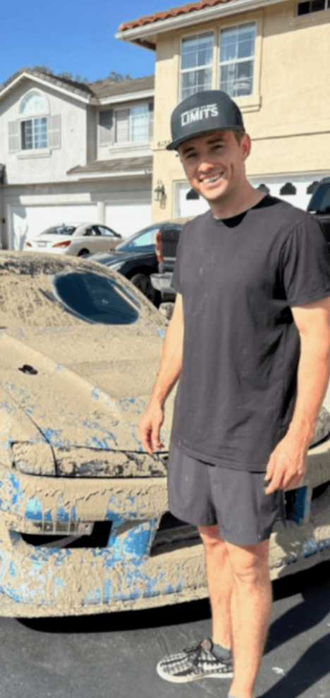 Creator Corey beside a mud-covered car
